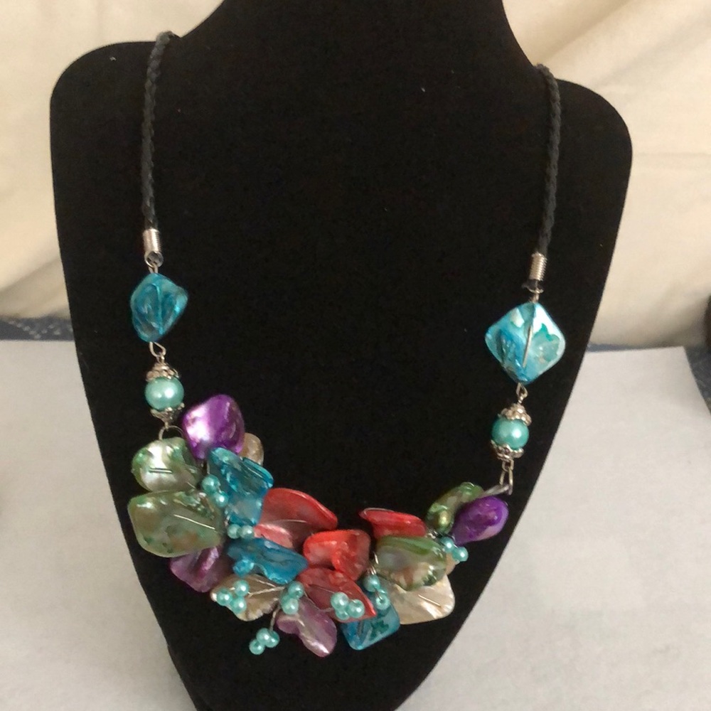 Lovely shell necklace on a braided leather band. It measures 22 inches long